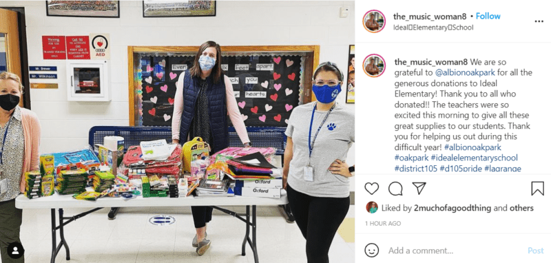 Three teachers standing at a table collecting school supply donations