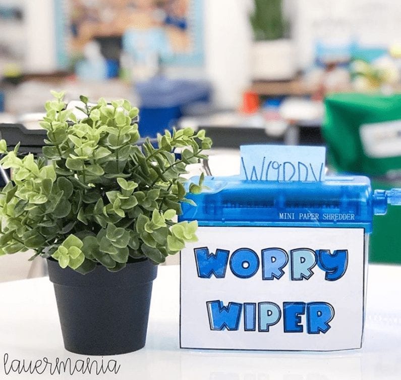 A fake plant is beside a box that says worry wiper. 